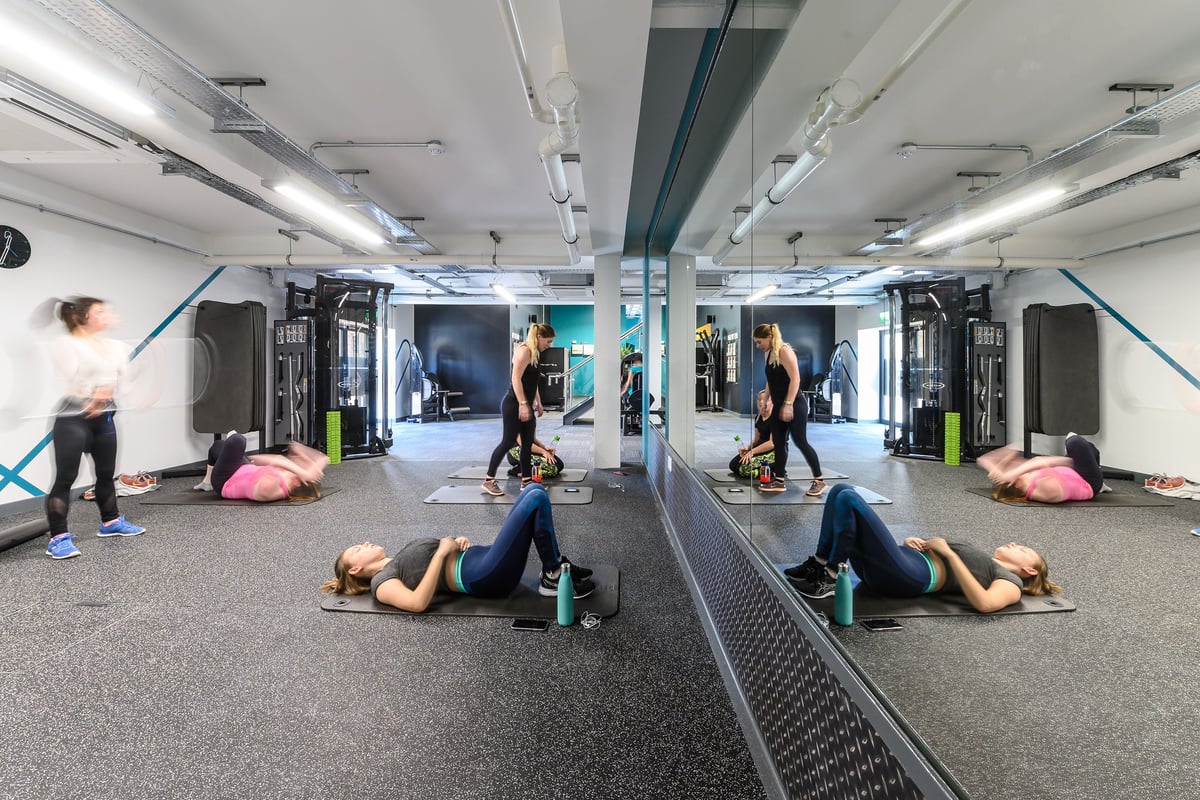 PureGym Bath Spring Wharf: Resistance machines, rubberised flooring, mirrored walls, and exercise balls in a gym studio.
