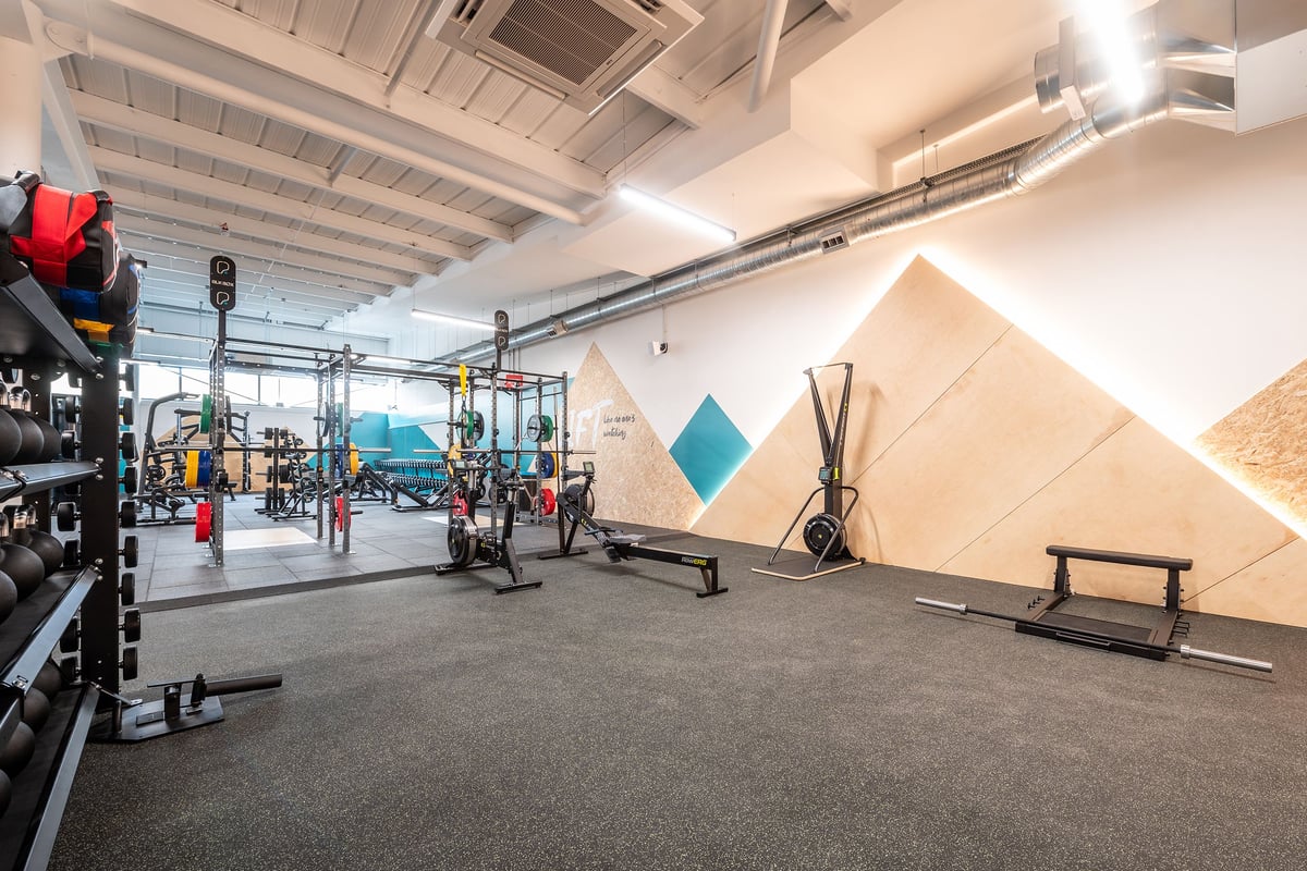 PureGym Bideford: Weightlifting racks, free weights, functional training rig, rubberized flooring, wall decor.