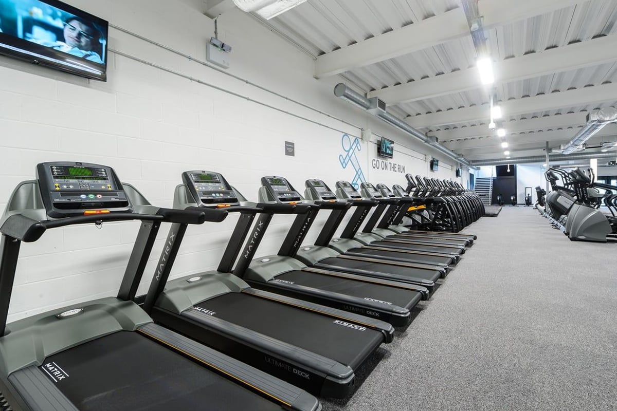 PureGym Leeds Regent Street: Rows of treadmills, cross-trainers, and stationary bikes in a brightly lit gym space.