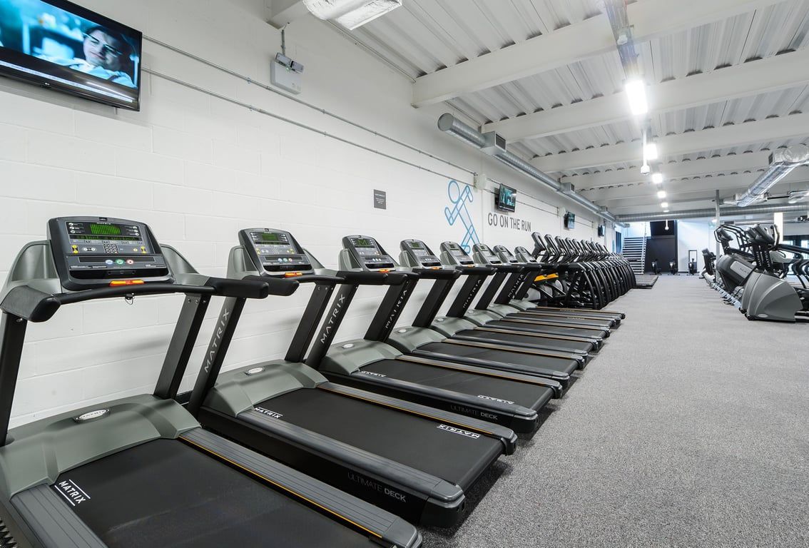 PureGym Leeds Regent Street: Rows of treadmills, cross-trainers, and stationary bikes in a brightly lit gym space.