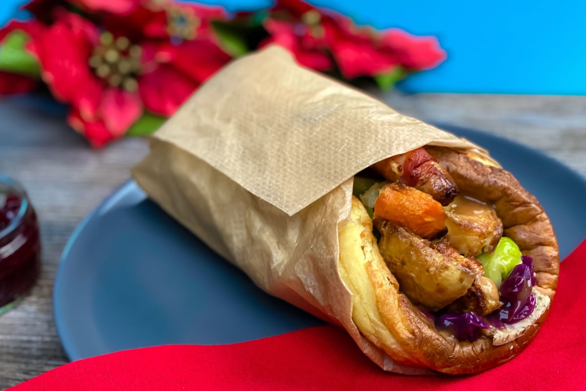 Christmas Yorkshire pudding wrap filled with roast potatoes and vegetables on a blue plate