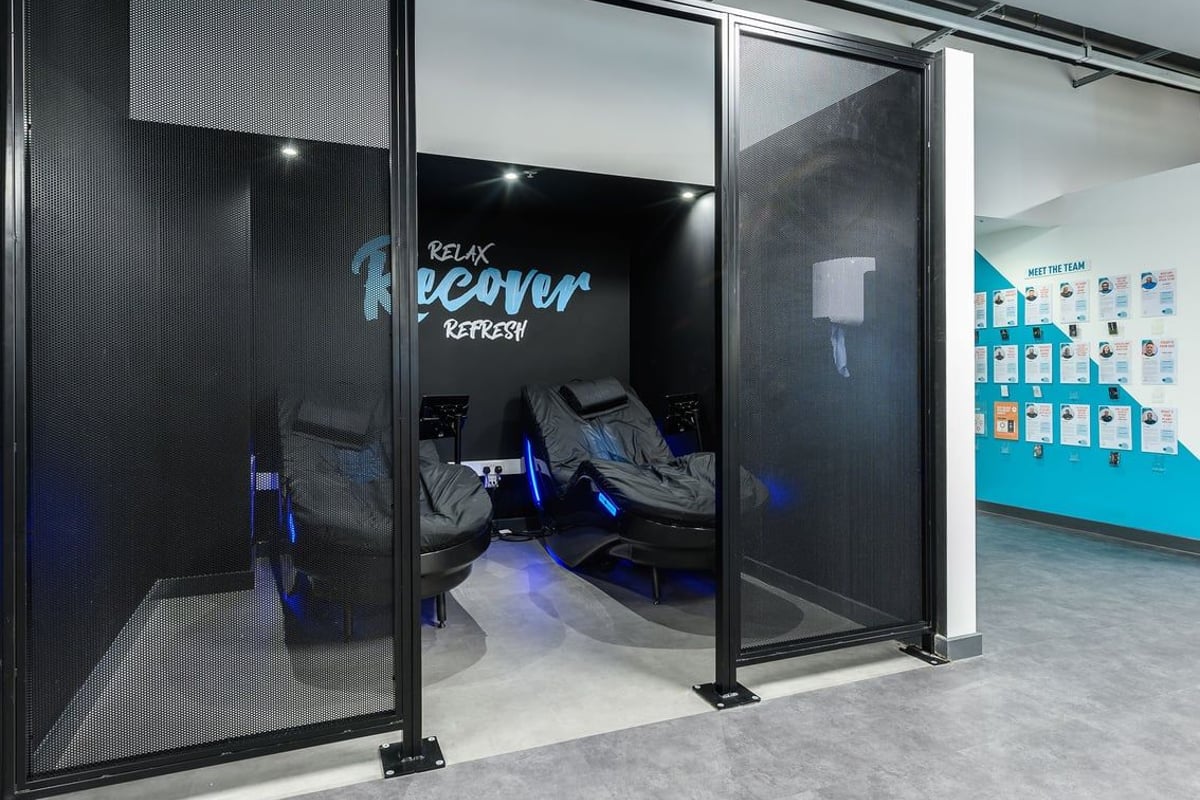 PureGym Leeds City Centre North: Massage chairs and relaxation lounge with neon "Relax Room" signage.