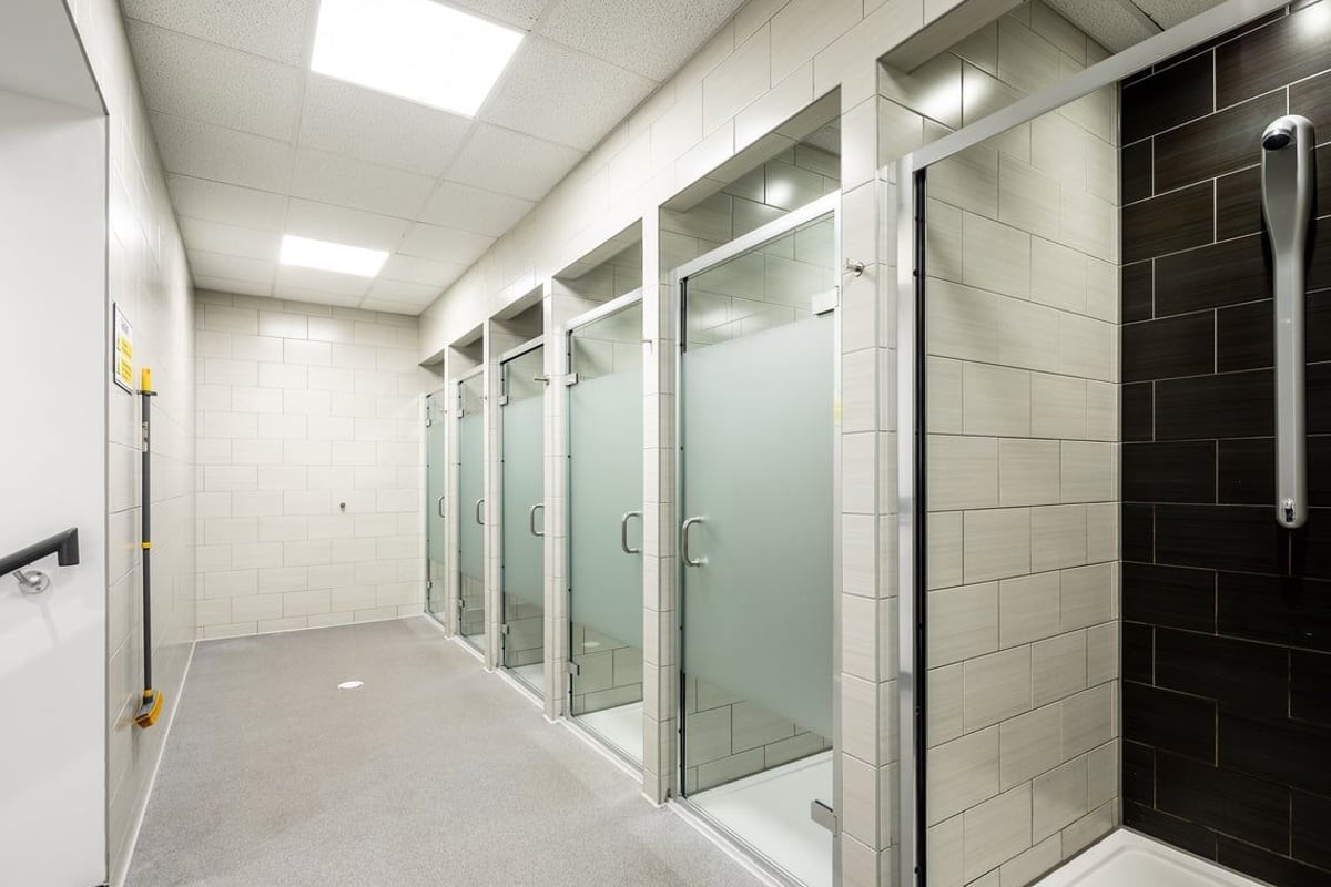 PureGym Cardiff Gate: Glass shower cubicles, tiled walls and flooring - a changing room facility.