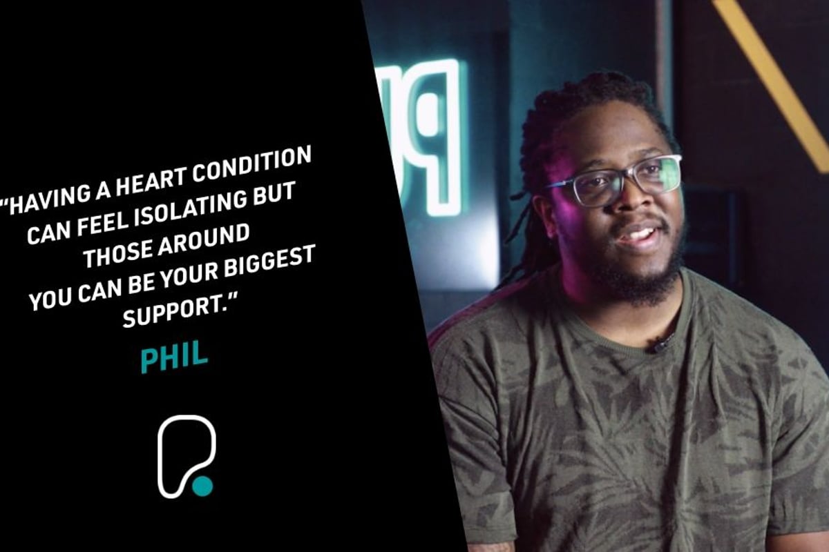 Man with glasses and dreadlocks speaking in a dimly lit room with a quote on the left side