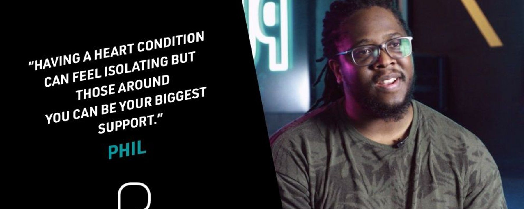 Man with glasses and dreadlocks speaking in a dimly lit room with a quote on the left side