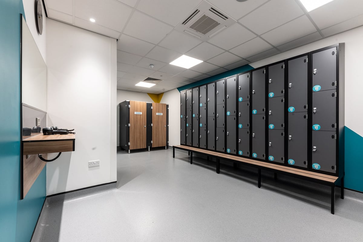 PureGym Watford Waterfields Retail Park: Rows of lockers, benches, showers in a changing room facility.