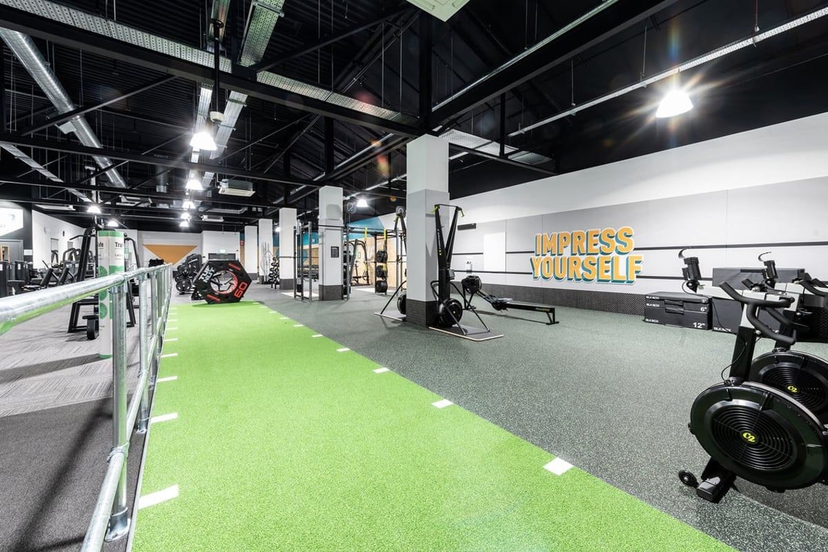 PureGym Bracknell: Weights, bikes, turf area, resistance machines in industrial-style gym space with motivational wall text.