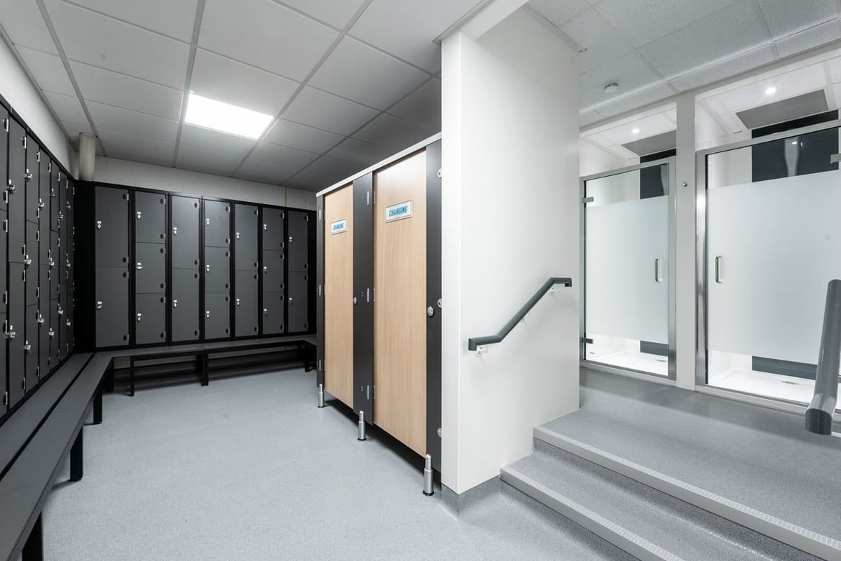 PureGym Ashford Warren Retail Park: Changing room with lockers, benches, and shower facilities.
