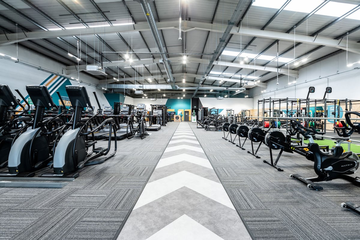 PureGym Newbury: Rows of treadmills, ellipticals, weights, benches, and exercise bikes in a modern gym setting.