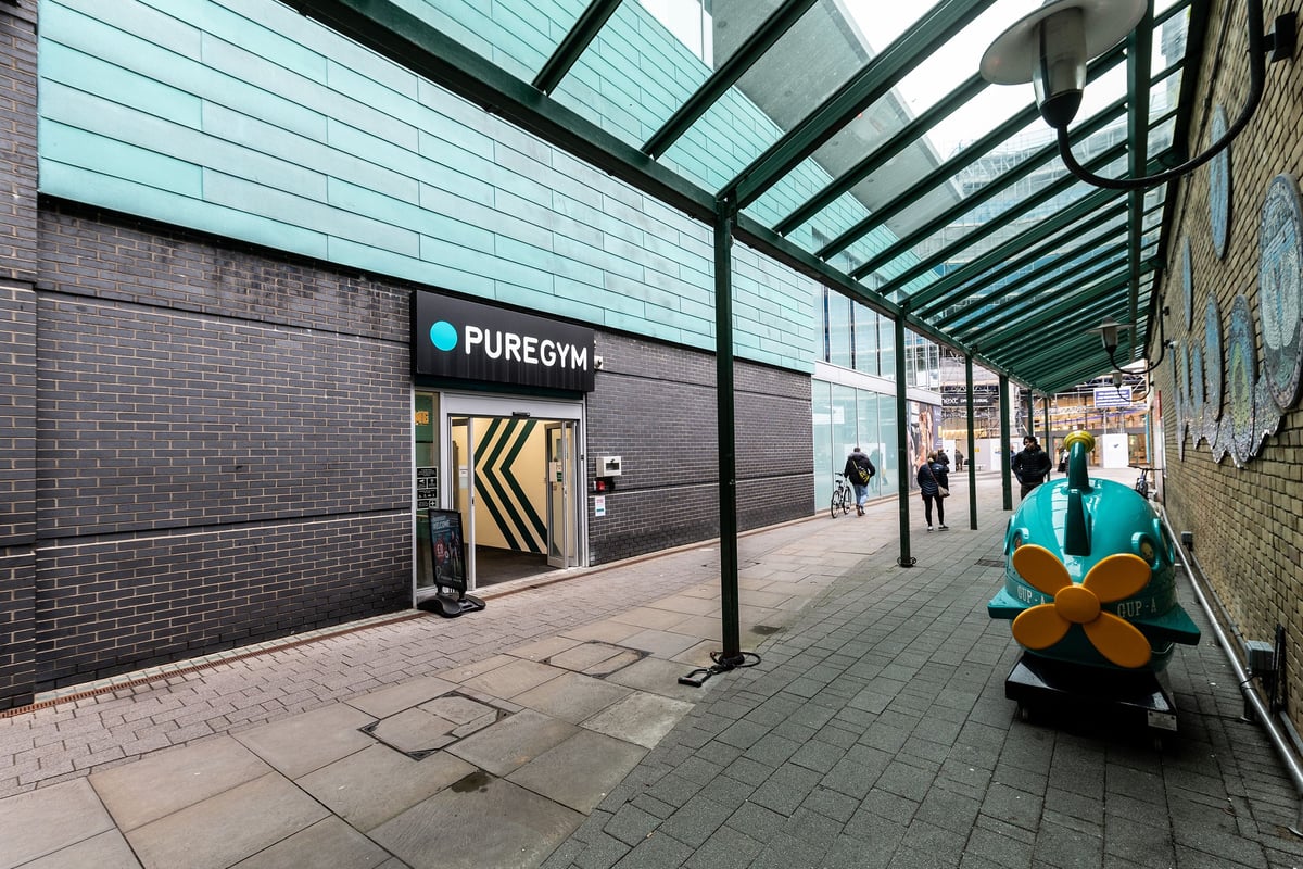 PureGym Walton-on-thames: Exterior walkway with Pure Gym signage, glass canopy, and bike sculpture.