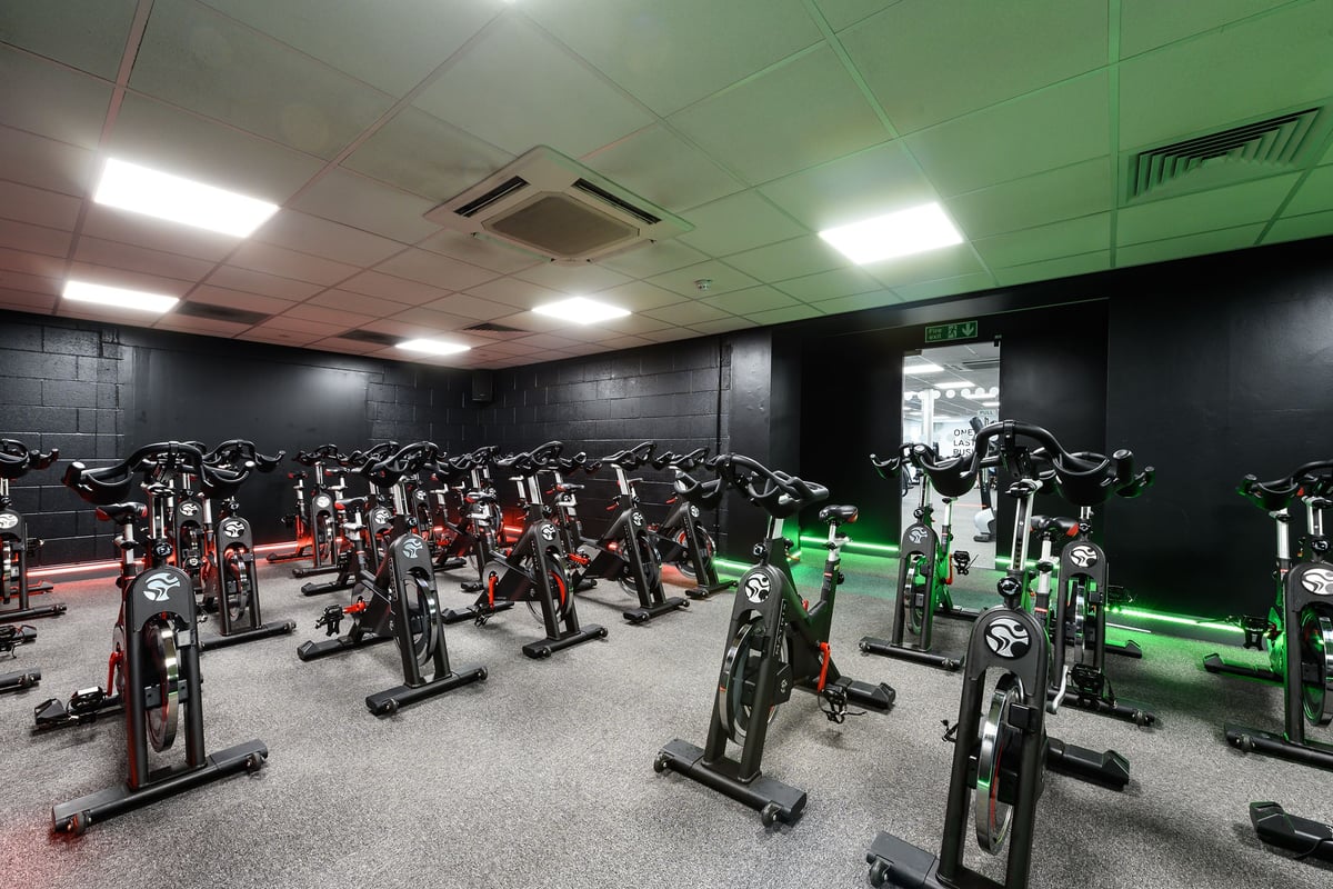 PureGym Burnham: Row upon row of stationary bikes fill a green-tinted room with fluorescent lighting.