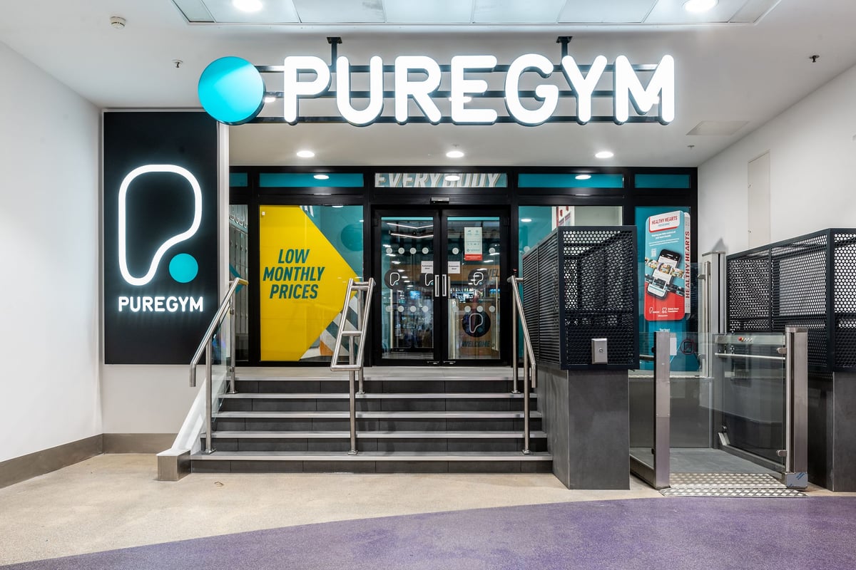 PureGym London Wood Green: Pure Gym store frontage with low monthly prices advertised, yellow banners, neon signage.