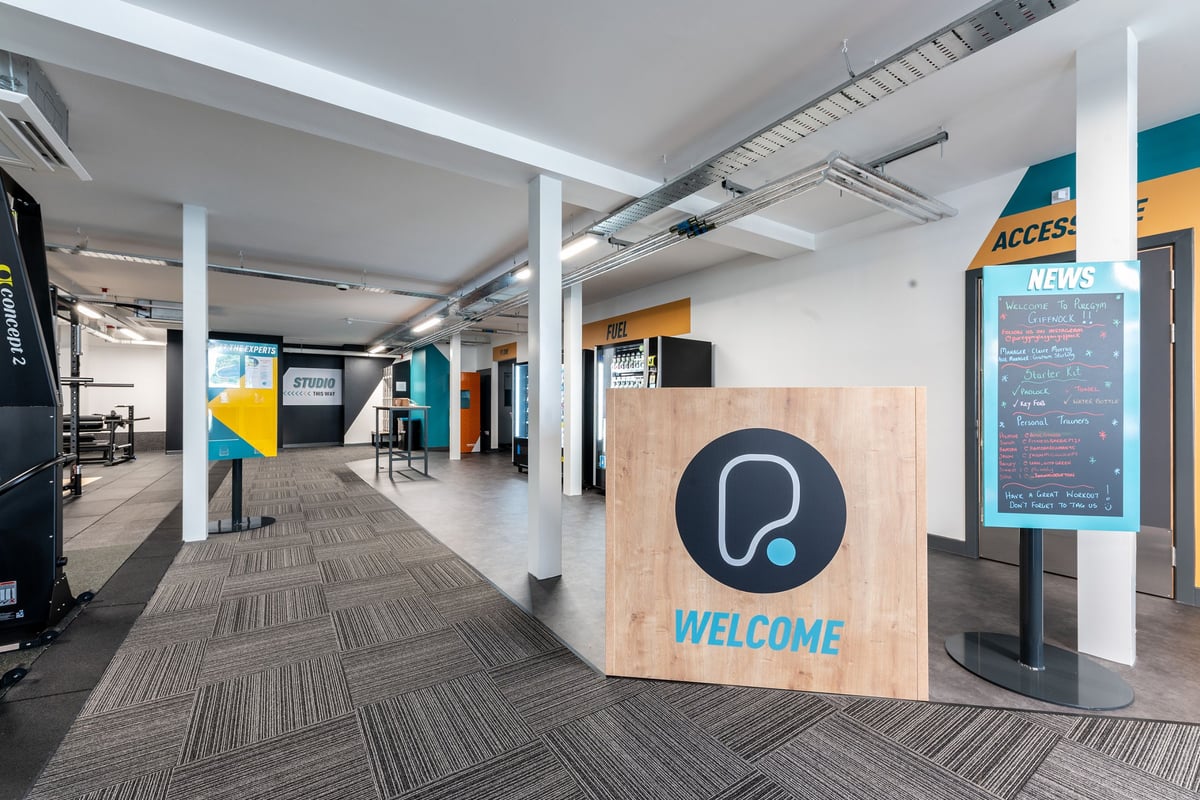PureGym Glasgow Giffnock: Reception area, welcome sign, access news board, modern industrial decor.