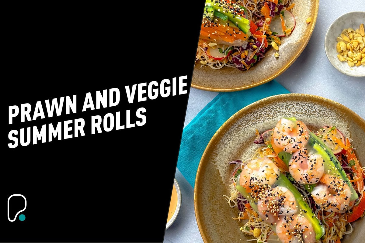 Two plates with prawn and vegetable summer rolls garnished with sesame seeds and peanuts