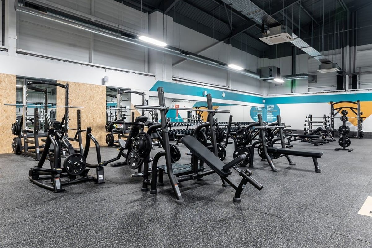 PureGym Sheffield Meadowhall Retail Park: Rows of weight machines, benches, and squat racks with rubberized flooring.