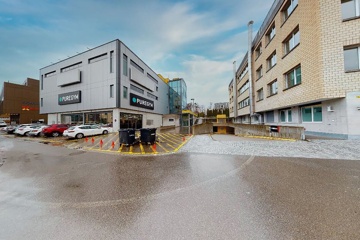 PureGym Pfäffikon: Aussenansicht des Gebäudes mit Parkplatz, PUREGYM-Beschilderung und gegenüberliegenden Wohnwohnungen.