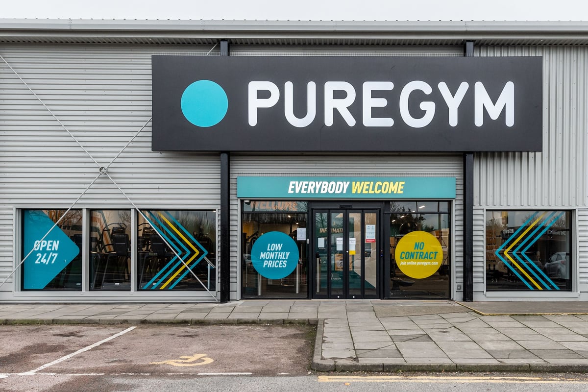 PureGym Newhaven: Gym front entrance with branded signage, vibrant window displays showcasing "Everybody Welcome" message.