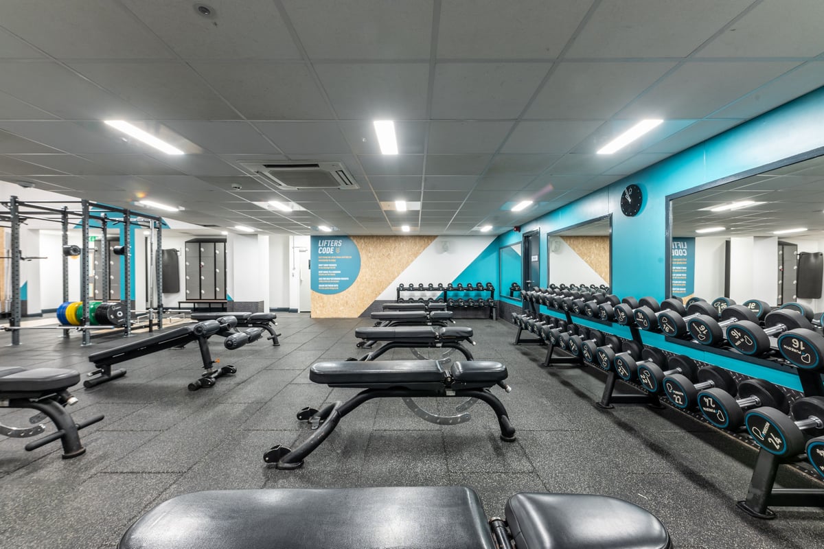 PureGym London Muswell Hill: Rows of benches, freeweights, resistance machines, and rubberized flooring in a gym studio.