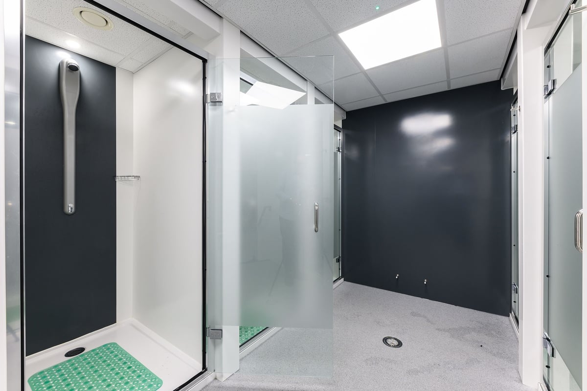 PureGym Nottingham Basford: Shower stalls, adjacent changing area with benches and lockers.