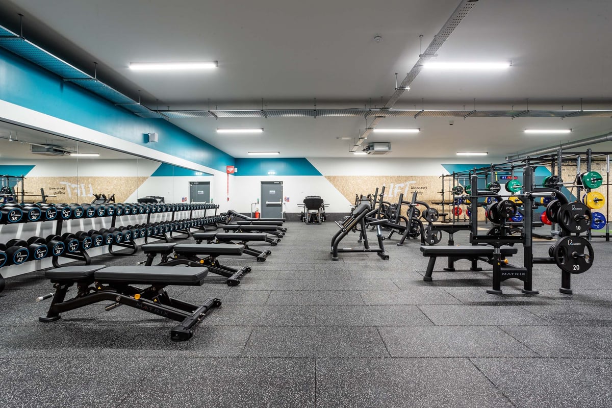 PureGym Llanelli free weights area with lots of benches and dumbbells