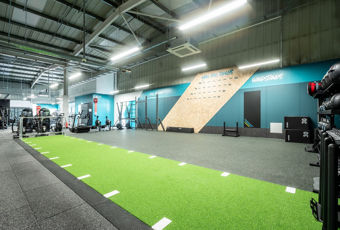 PureGym Horsham: Weights racks, climbing wall, artificial turf area, weight benches, rubberised flooring.