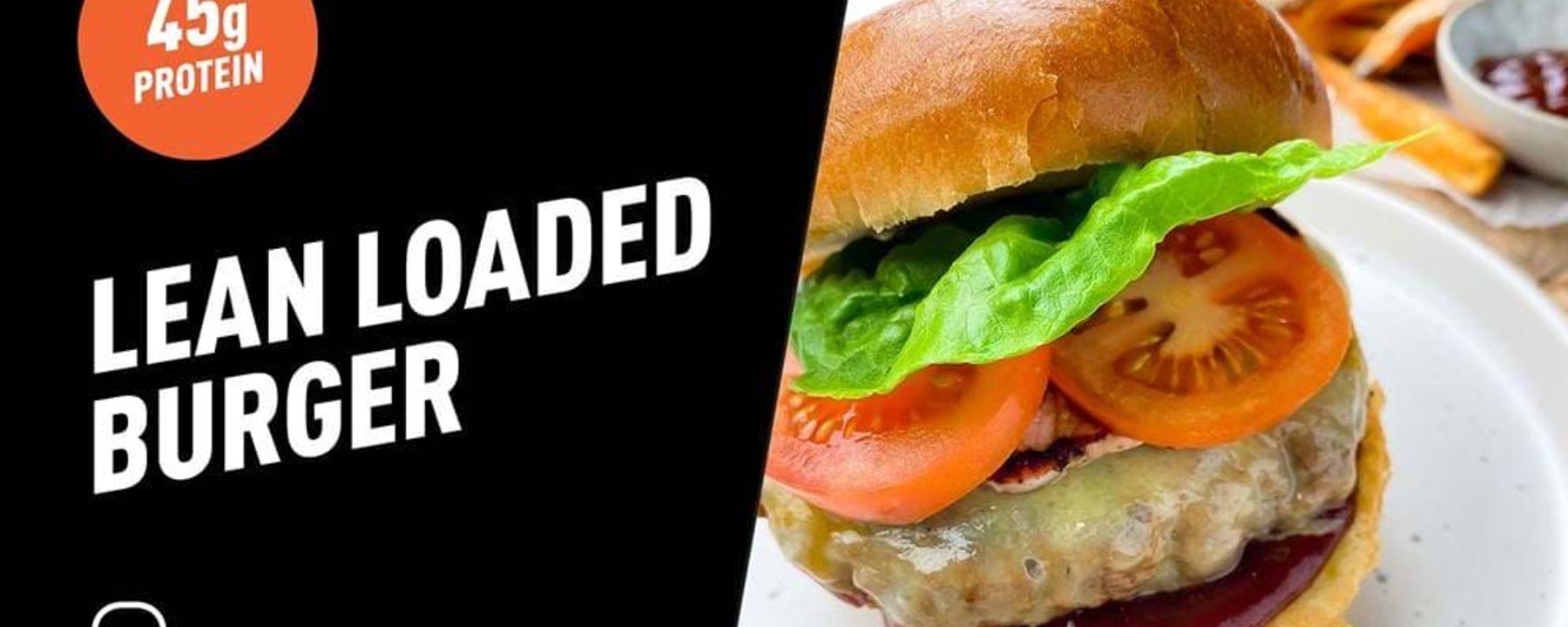 Burger with lettuce, tomato, cheese, and sauce on a white plate with fries and ketchup.