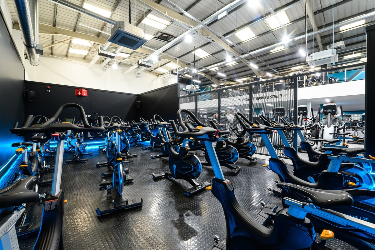 PureGym London Hayes: Rows of stationary bikes, treadmills, and ellipticals in a gym with mirrored walls.