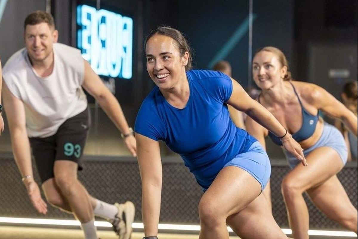 3 smiling PureGym members taking part in a class
