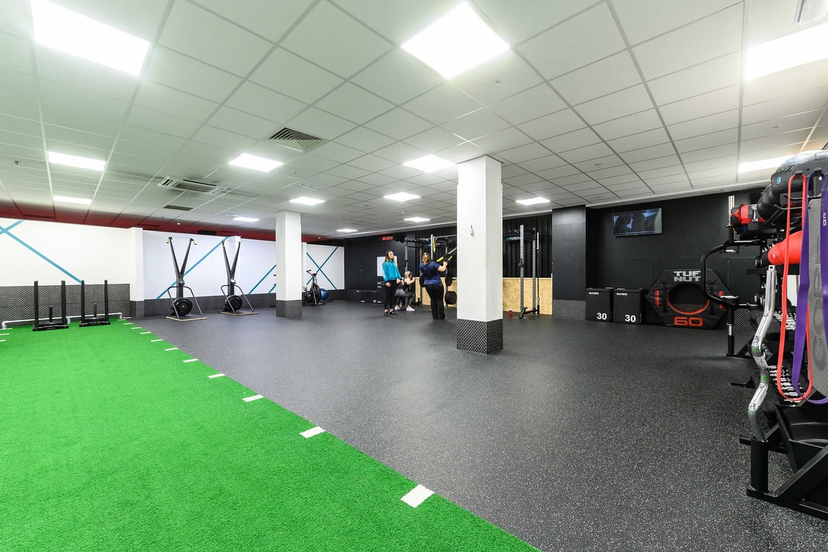 PureGym Glasgow Shawlands: functional training area with green turf, rubberised flooring and resistance bands in a gym
