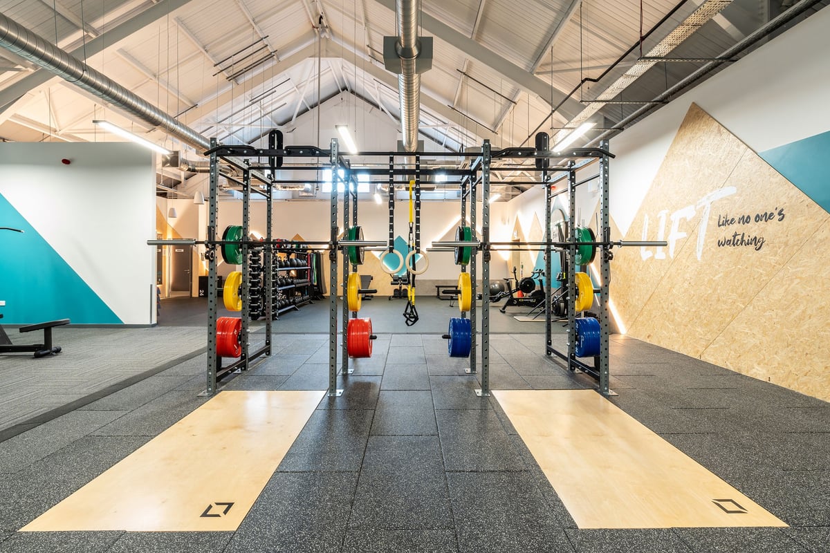 PureGym Kendal: Rig with pull-up bars, resistance bands, kettlebells, and wall graphics for motivation.