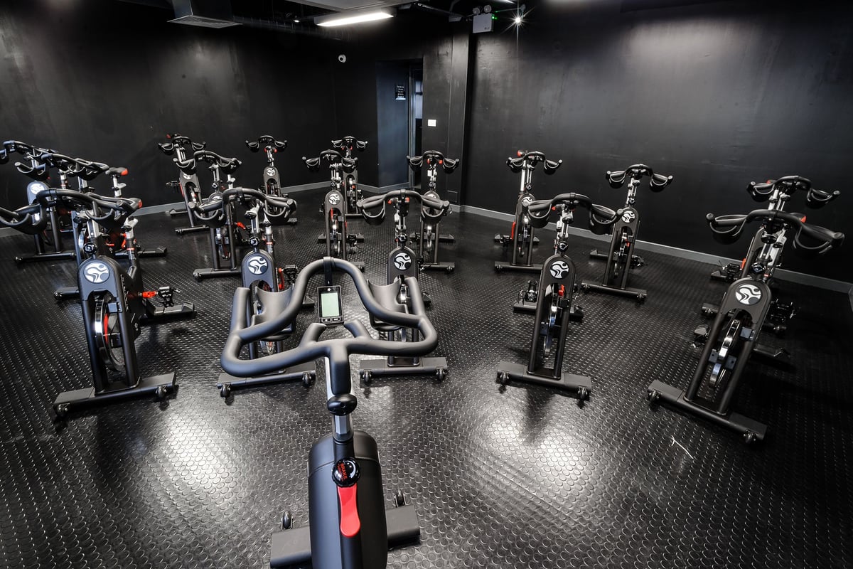 PureGym Dundee: Rows of stationary bikes arranged in dim studio lighting.