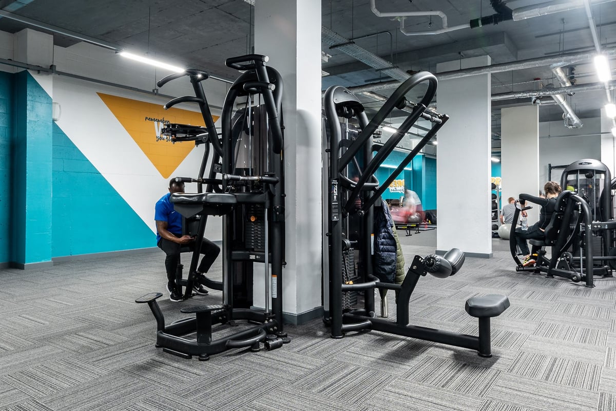 PureGym London Hammersmith Palais: Exercise machines, free weights, and a modern gym interior with colorful accent walls.