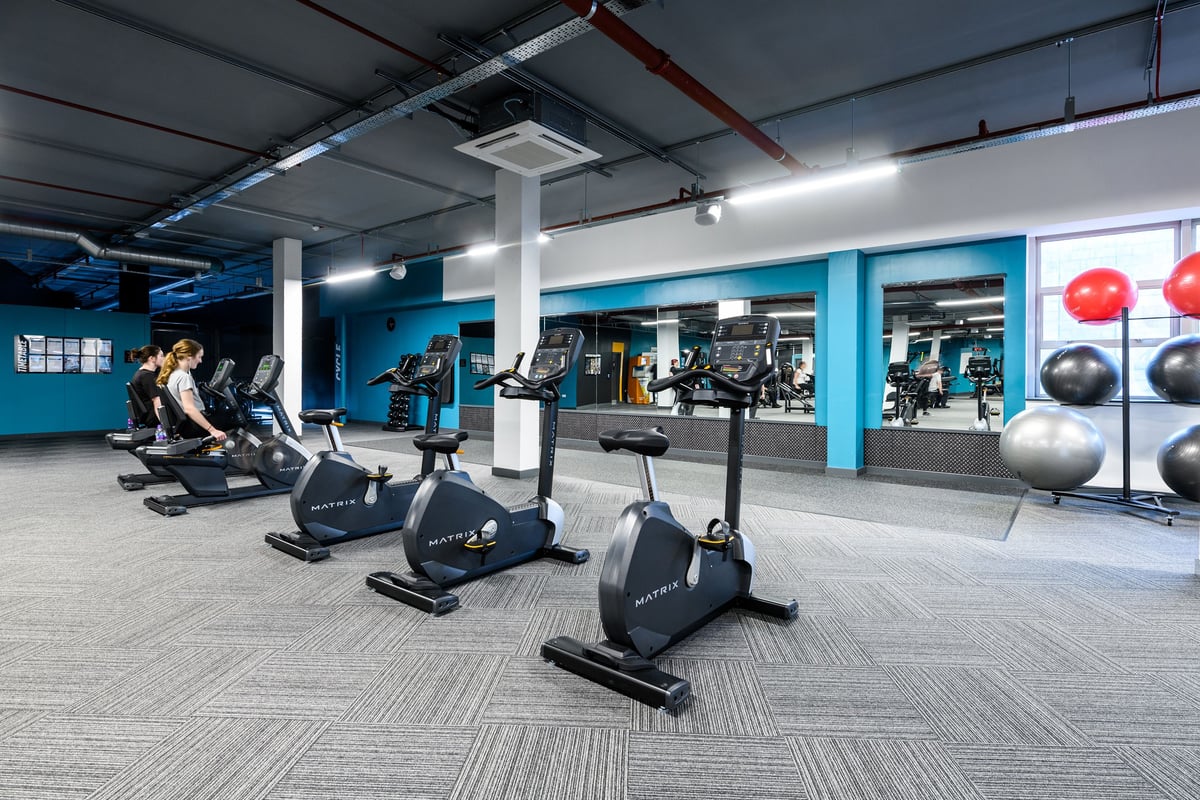 PureGym Basildon: Stationary bikes, exercise balls, weight benches, and resistance machines in a gym studio.