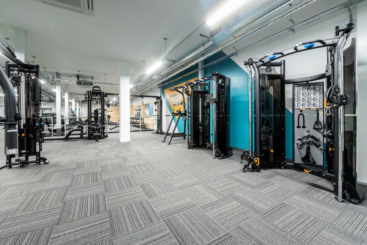 PureGym Yeovil Houndstone Retail Park: Rows of cable machines, squat racks, benches, and weights in a modern fitness studio.
