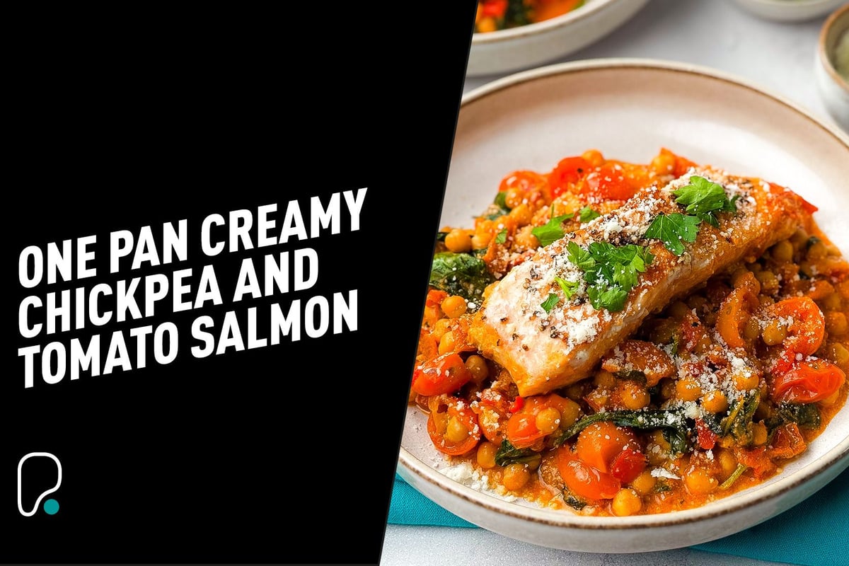 Salmon fillet on creamy chickpea and tomato stew garnished with parsley and cheese
