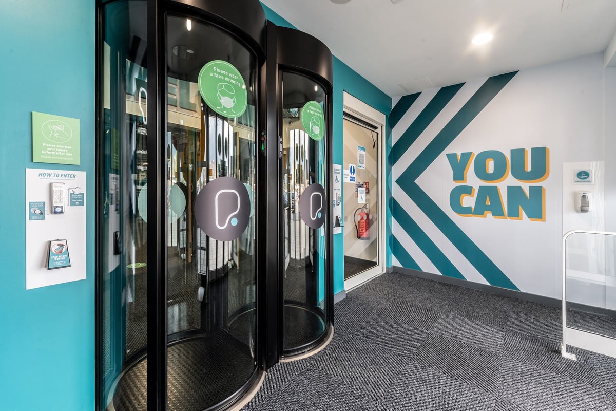 PureGym Bournemouth Mallard Road Retail Park: Revolving doors, fitness posters, and "YOU CAN" signage at the gym entrance.
