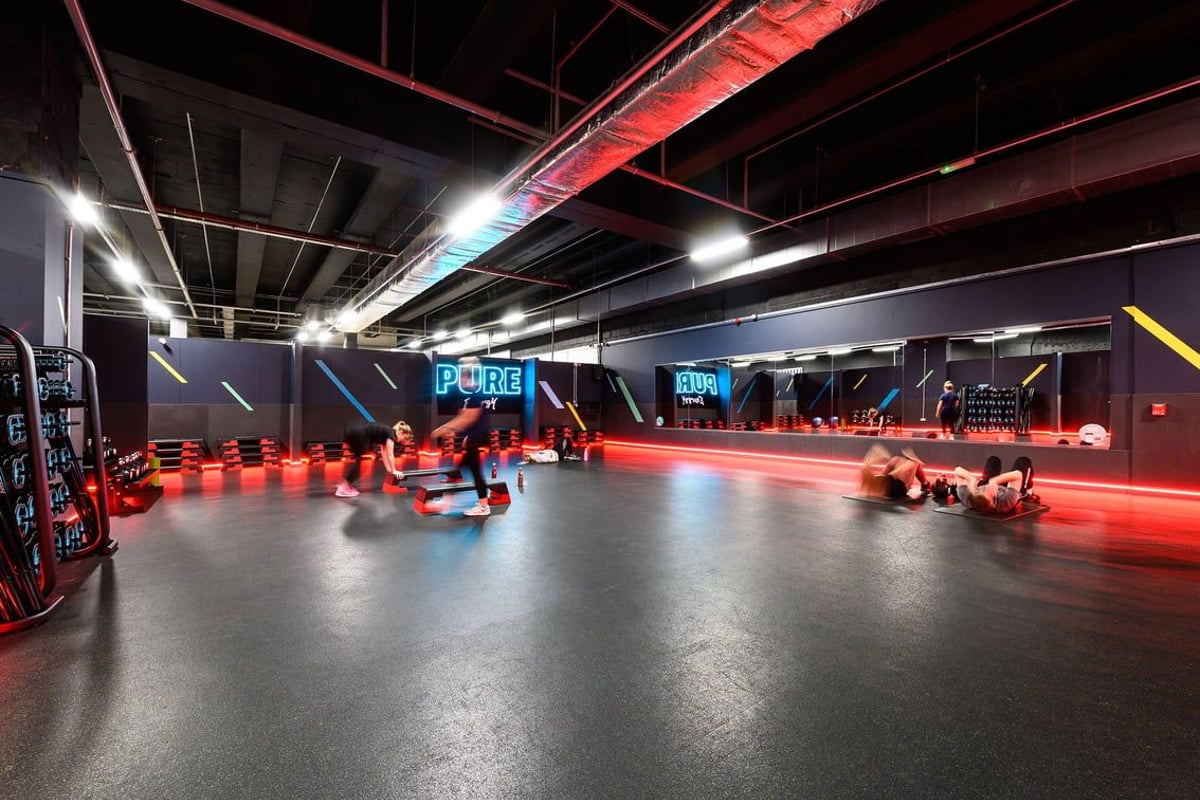 PureGym Leeds City Centre North: Battle ropes, punching bags, and wall-mounted strength equipment in a dimly lit space.
