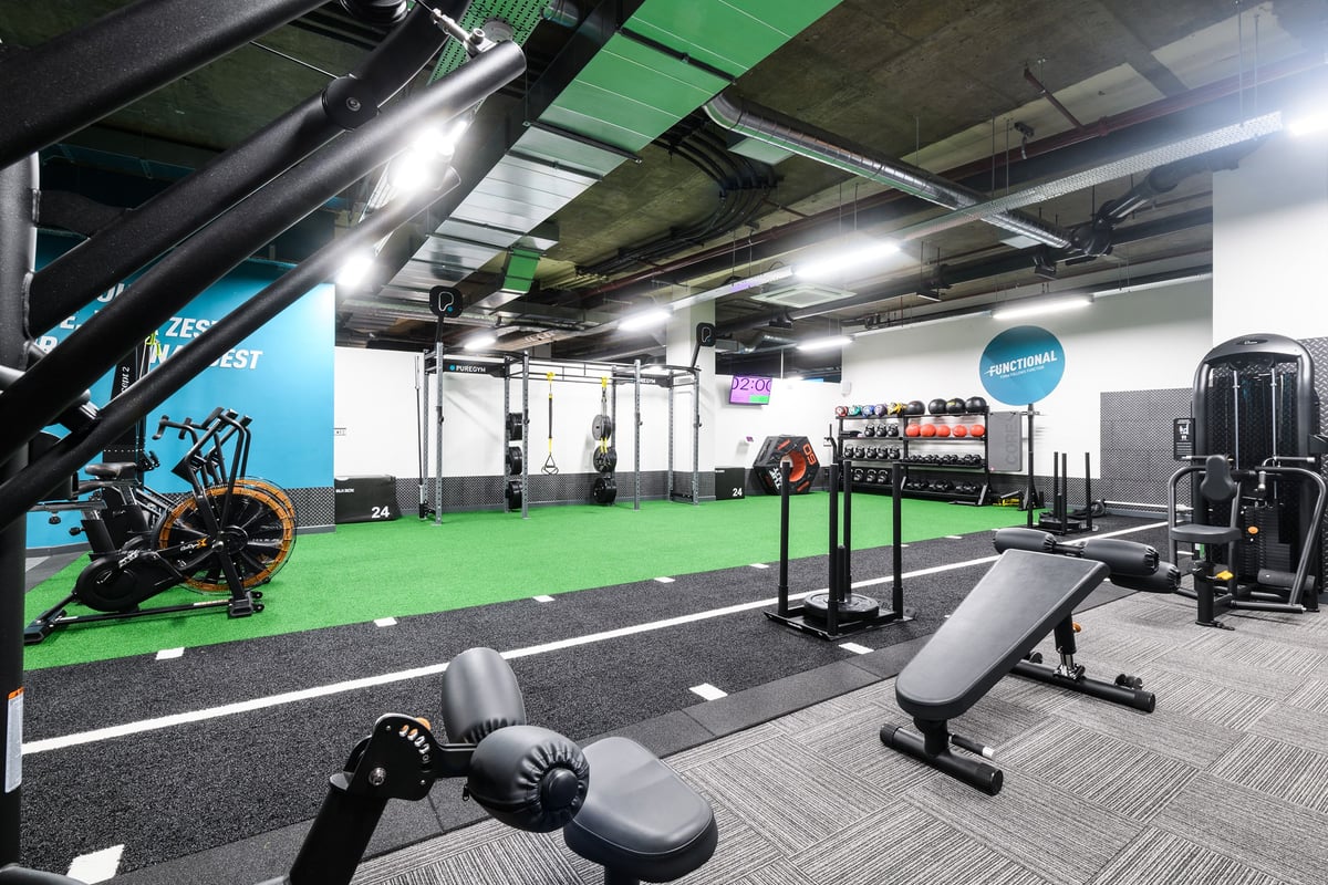 PureGym London Tottenham Court Road: Gym interior with weight machines, free weights, turf flooring, and mirrored walls.