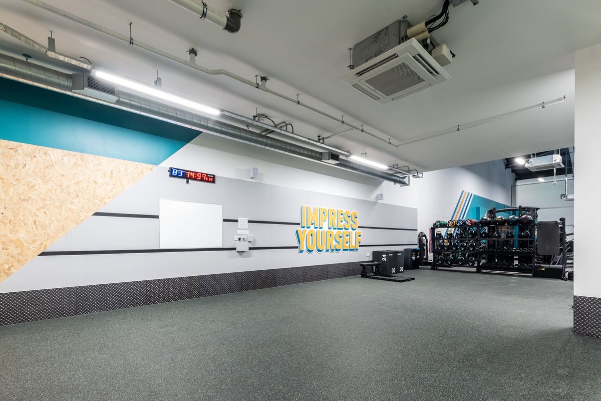 PureGym Redditch Ringway: Cardio machines, weight racks, resistance bands, and mirrored wall in fitness studio.