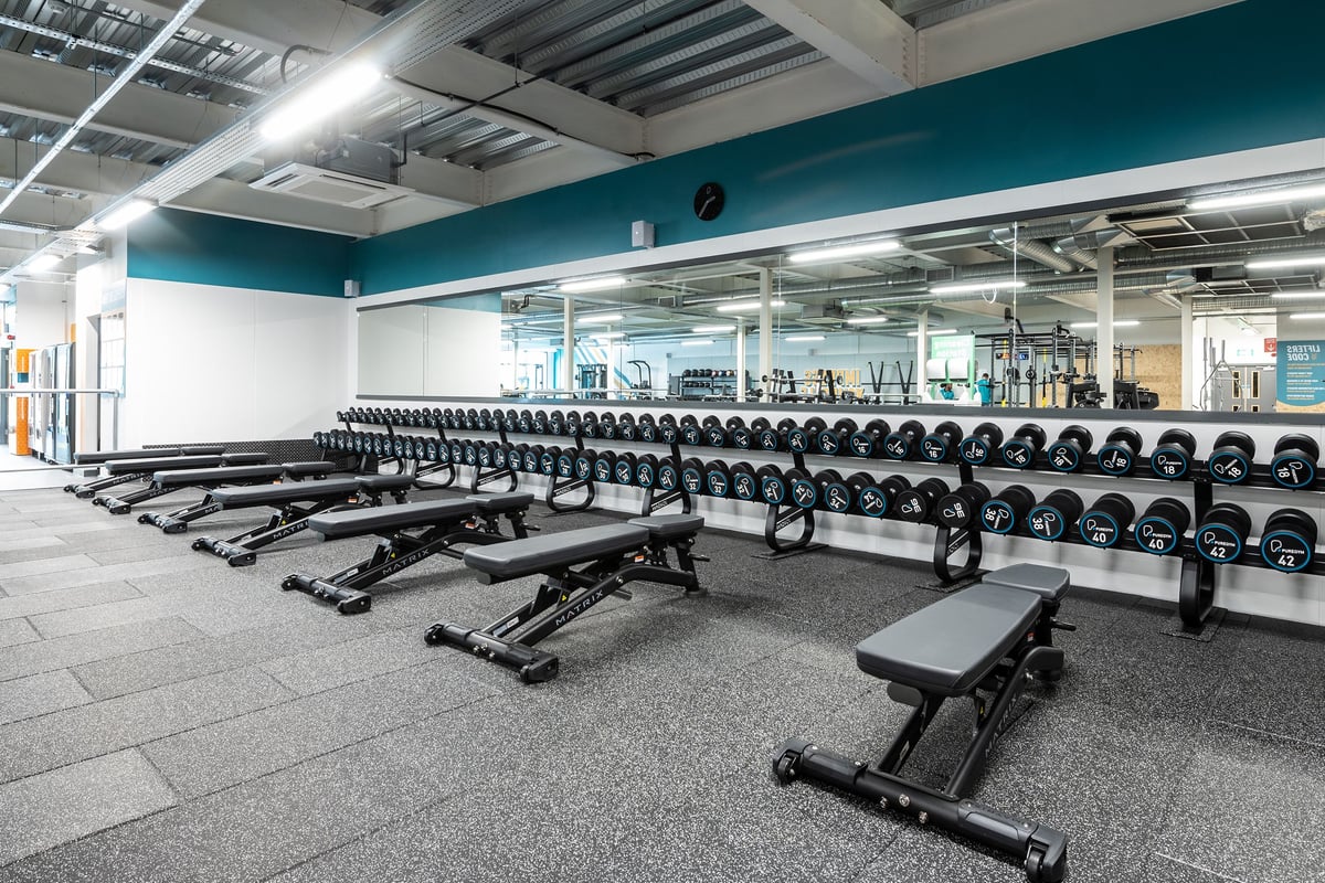 PureGym Cheshunt Brookfield Shopping Park: Rows of dumbbell racks, weight benches, and rubberized flooring.