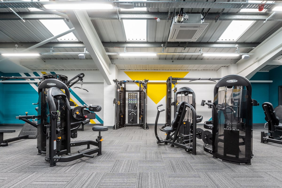 PureGym Guiseley: Resistance training machines, weight racks, and rubberized flooring in a bright gym setting.