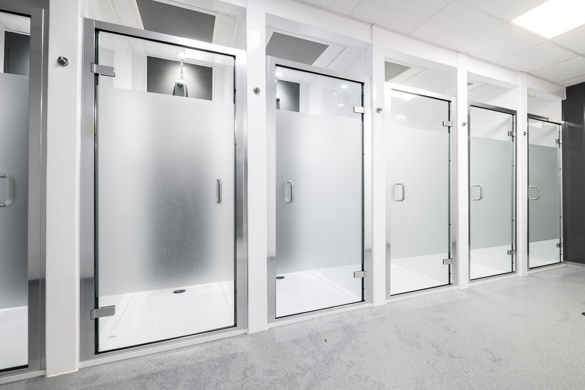 PureGym Aberdeen Wellington Circle: Rows of stainless steel lockers or changing room cubicles with glass door panels.