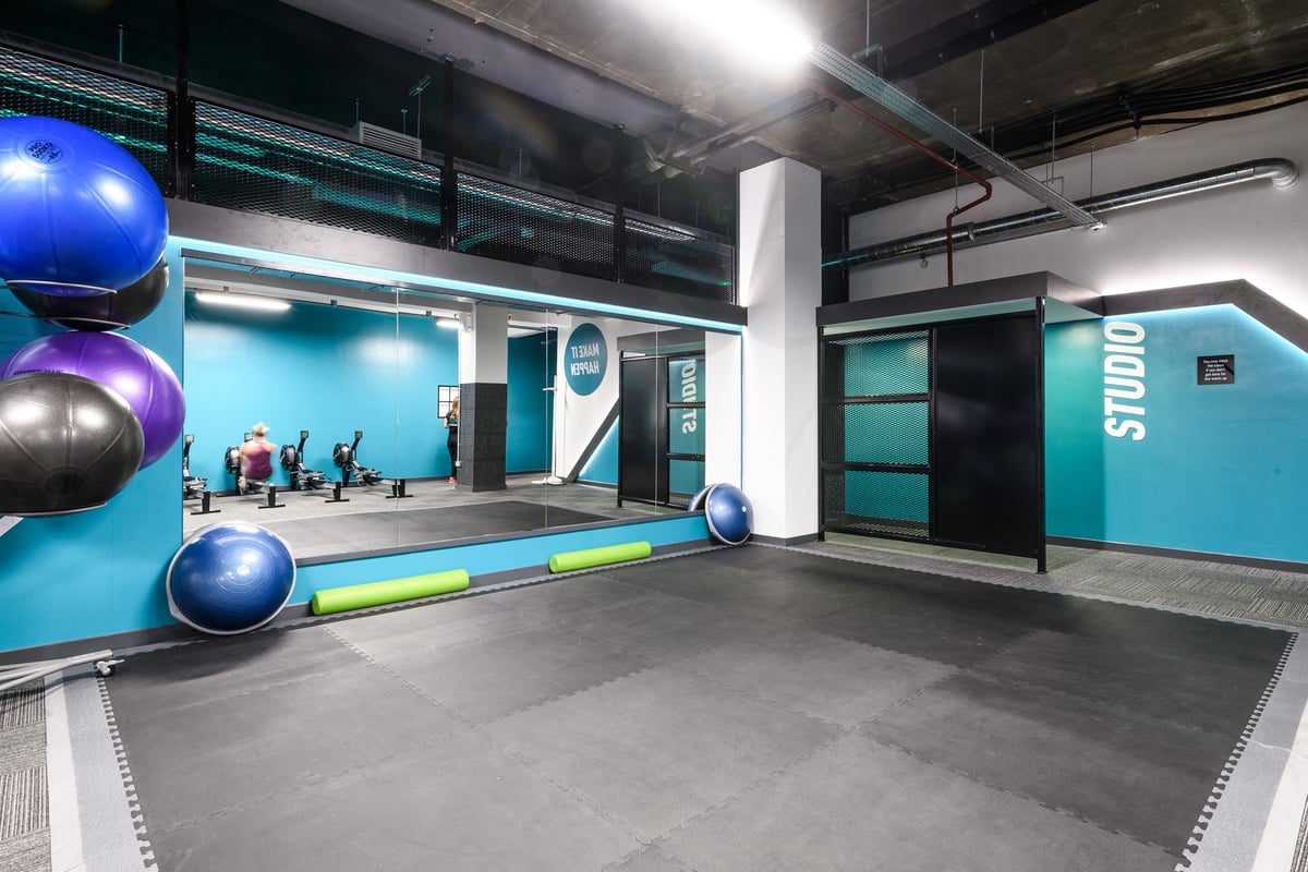 PureGym London Tottenham Court Road: Exercise studio with colourful fitness balls, resistance tubes, and mirrored wall.