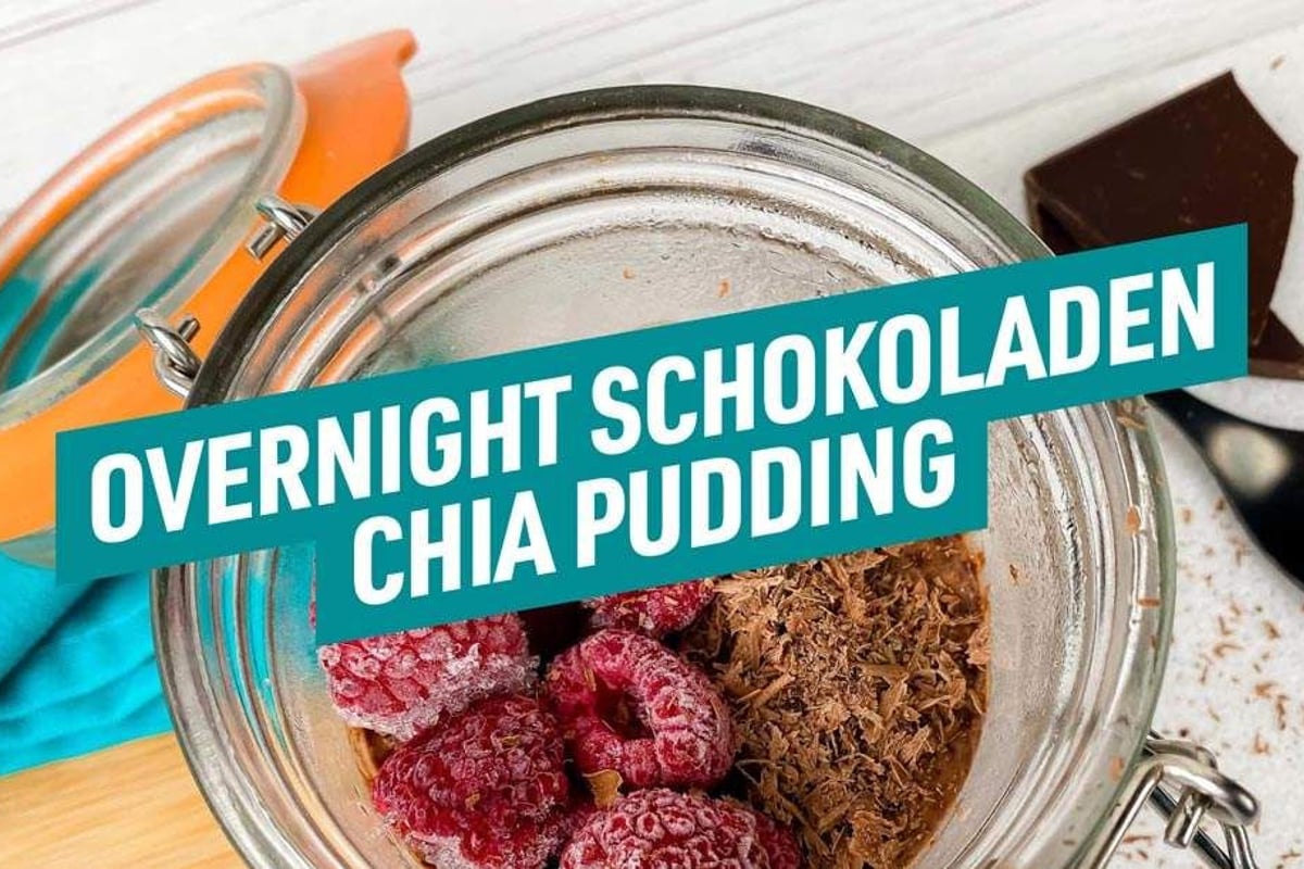 Pot en verre de pudding chia au chocolat garni de framboises surgelées et copeaux de choco