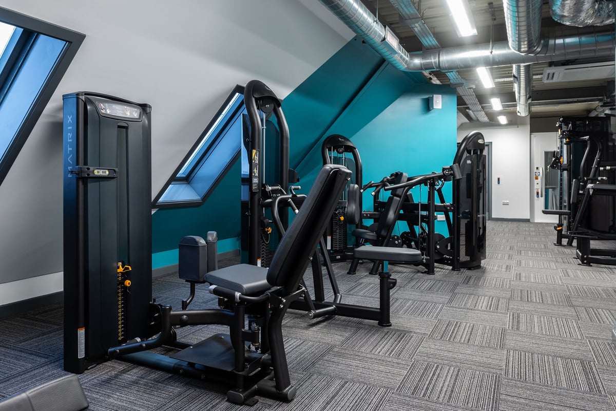 PureGym Brentwood: Resistance machines, benches, free weights, rubber flooring in a teal and grey-toned gym studio.