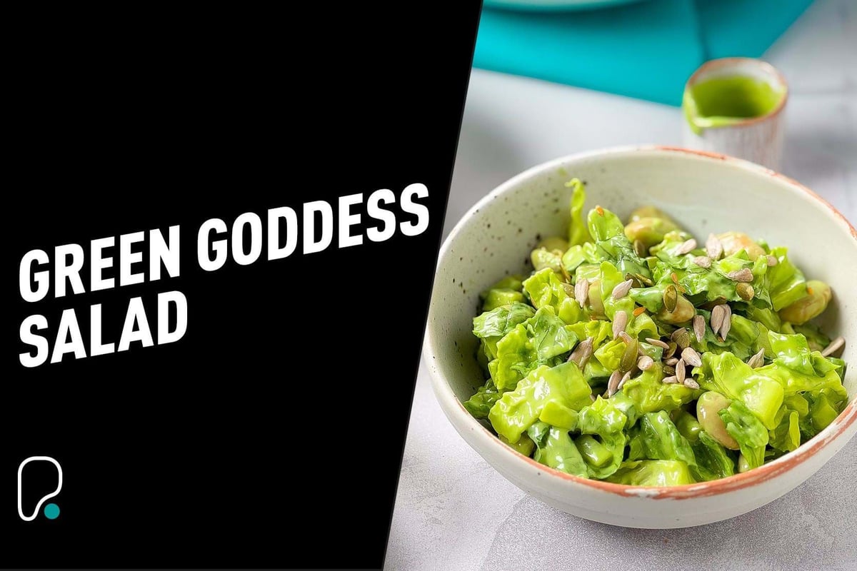 Bol de salade verte avec feuilles et graines, sauce verte en arrière-plan