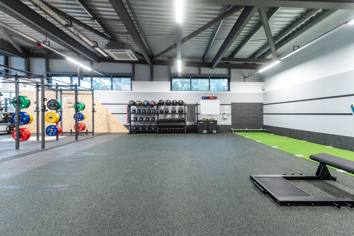 PureGym Plymouth Derriford: Gym with weight plates, squat racks, rubberized flooring, weightlifting platforms.
