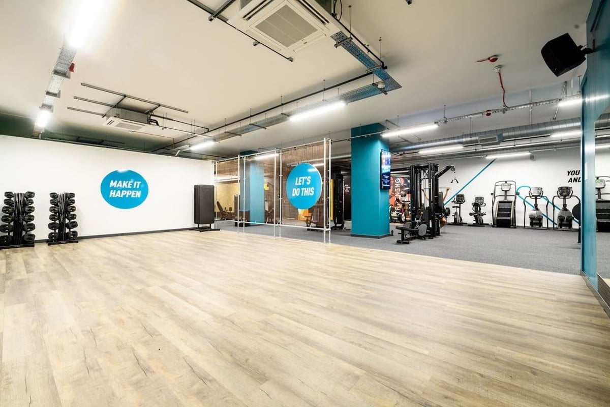 PureGym East Grinstead: Rubberized flooring, weight racks, resistance machines, and branded workout space signage.