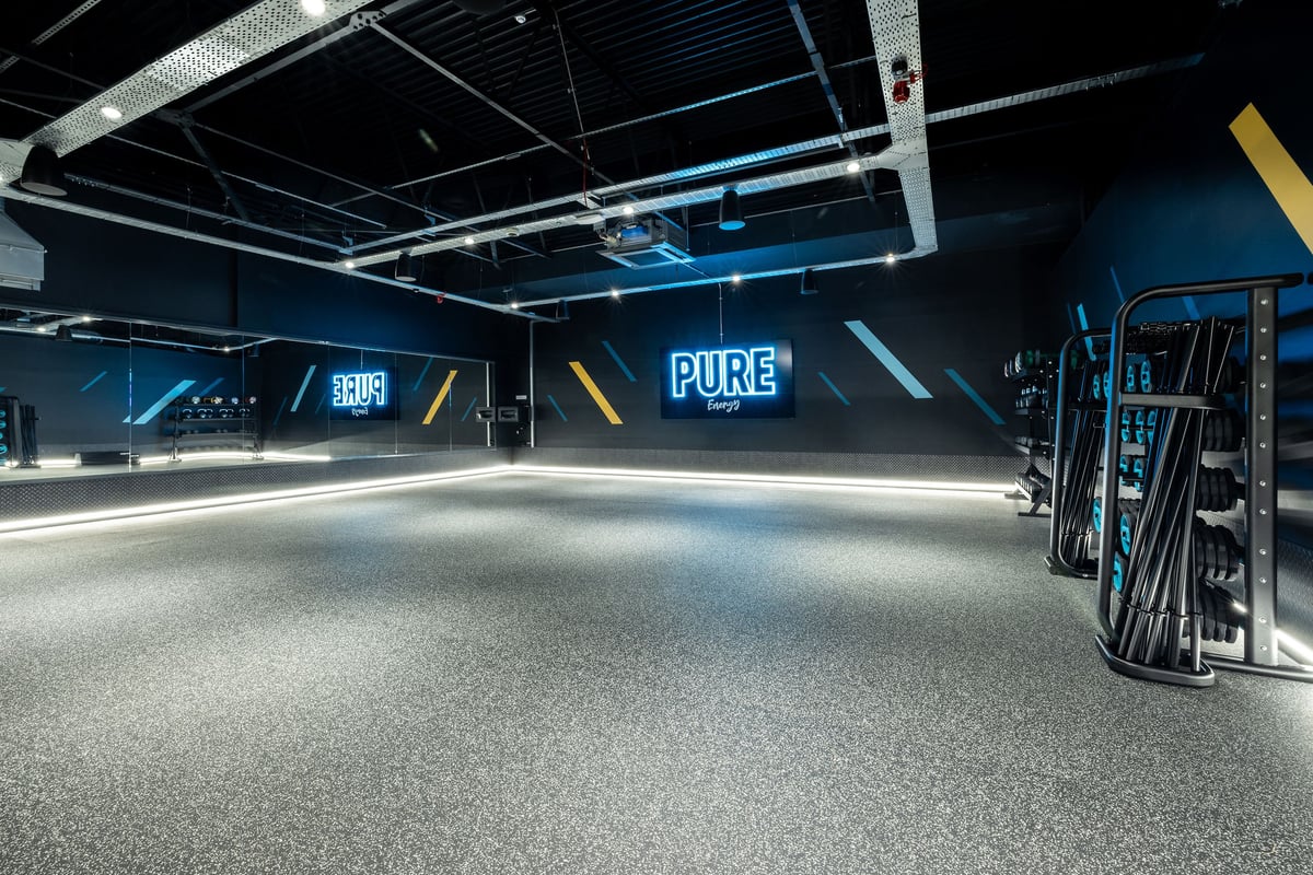 PureGym Washington: Strength training area with rubberised flooring, neon lighting, and Pure branding.