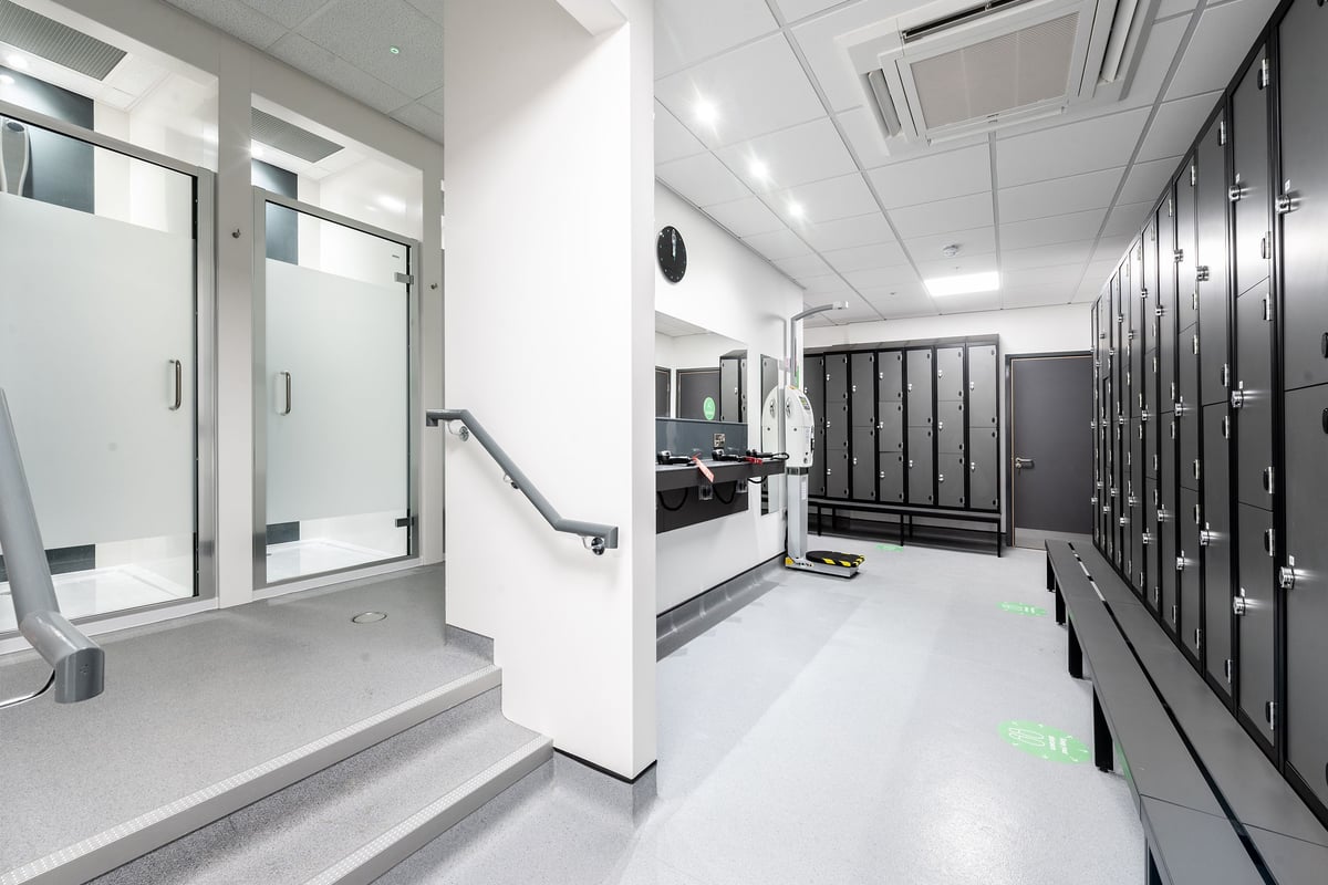 PureGym Gravesend: Changing room with lockers, benches, and private shower cubicles.